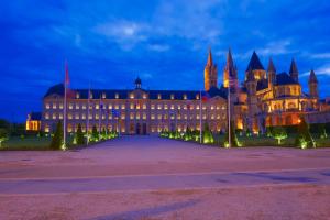 a large building with christmas trees in front of it at Villa Robs - Studios et Appartements - Localisation idéale in Caen
