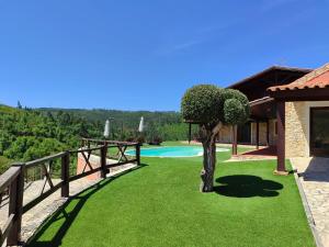 a garden with a tree in the middle of a yard at Lake Prestige Villa Castelo de Bode, Tomar in Tomar