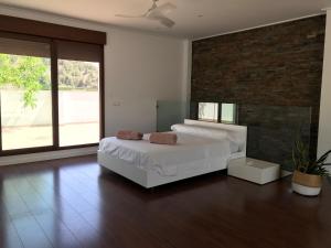 a bedroom with a white bed and a brick wall at Villa Xauxa - Vida mediterránea in Gandía