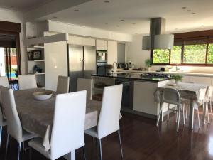 a kitchen with a dining table and white chairs at Villa Xauxa - Vida mediterránea in Gandía