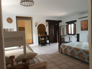 a room with a bedroom with a bed and a mirror at Guesthouse Un Poco Mas in Canillas de Aceituno