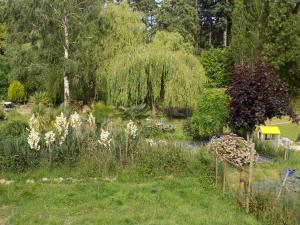 a garden with a bunch of flowers and trees at Caravan du Loch in Gaël