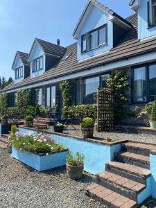 a house with some plants in the front yard at Rowan House B&B Rooms & A Self Catering Apartment in Lochgoilhead
