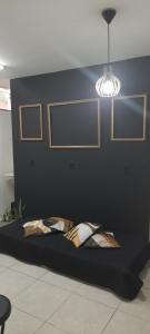 un letto in una stanza con una parete nera e una luce di Apart 2 Qdras da Praia a Rio de Janeiro