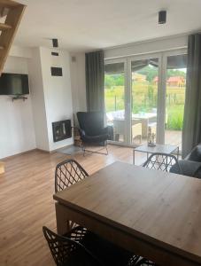 a living room with a table and chairs at Perły Roztocza - Domek całoroczny in Krasnobród