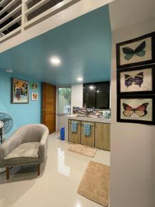 a living room with a chair and a kitchen at Tierra Bukid en Amadeo in Cavite +16 photos