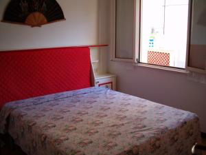 een slaapkamer met een bed met een rood hoofdeinde en een raam bij Casa Valentina ANIMALI NON AMMESSI in Montesilvano