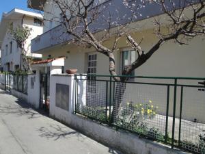 een hek voor een huis met een boom bij Casa Valentina ANIMALI NON AMMESSI in Montesilvano