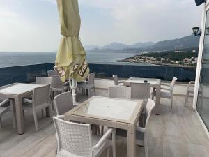 a patio with tables and chairs and an umbrella at Morski plamen in Kruče