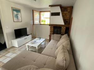 a living room with a couch and a fireplace at Appartement Cocoon avec jardin et vue montagne in Laruns