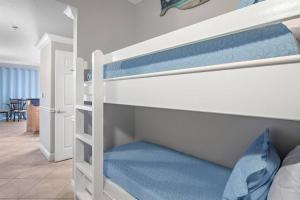 a bedroom with two bunk beds with blue sheets at Panoramic Oceanview Retreat in Miramar Beach in Destin +24 photos