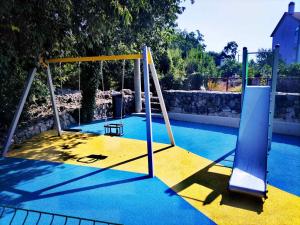 an empty playground with a swing set in a pool at Apartman Tri palme in Gabonjin