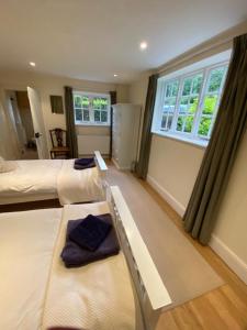 a bedroom with two beds and a window at Stunning 3 bedroom 3 bath self catering cottage nr Stonehenge, Longleat, Avebury and Bath in Pewsey