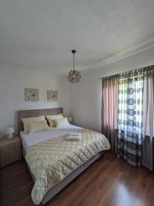 a bedroom with a large bed and a chandelier at Vacation Home Keskic in Velika Gata