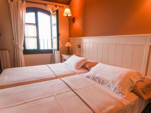 two beds in a room with a window at Casa Puertas Bed & Breakfast sl in Oia