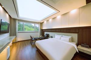a bedroom with a large white bed and a skylight at Hotel Demer Mokpo in Mokpo +54 photos