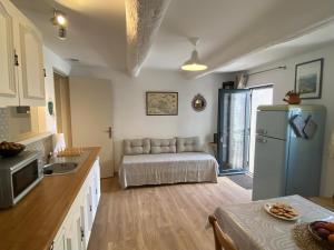 a kitchen with a couch and a refrigerator at Gîte La Tarente in Montfrin