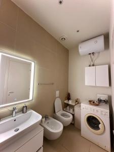 y baño con lavamanos y lavadora. en Pacific 2 Bedroom Villa Palase, en Palasë
