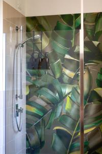 a bathroom with a shower with a mural of leaves at Villa del Parco in Poggi