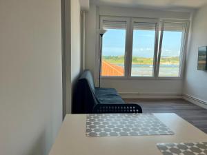 sala de estar con sofá, mesa y ventanas en Apartamentos Mi Suances Playa, en Suances