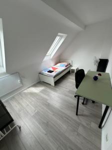 a room with a bed and a desk and a table at Zentral gelegenes Apartment am Bunter Garten MG09 in Mönchengladbach