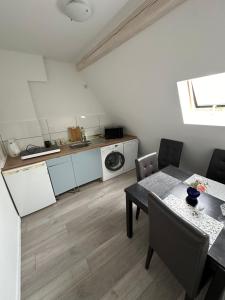 a dining room with a table and a kitchen at Zentral gelegenes Apartment am Bunter Garten MG09 in Mönchengladbach