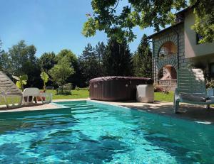 a swimming pool with two lawn chairs next to a house at Vacation Home Keskic in Velika Gata