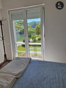 a bedroom with a bed and a large window at Apartments Sokolović in Višegrad +55 photos