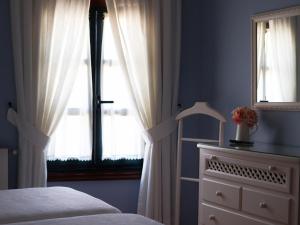 a bedroom with a bed and a window and a dresser at Casa Puertas Bed & Breakfast sl in Oia