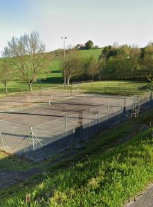a tennis court with a net in a field at Gîte FABEL HAUT in Durfort