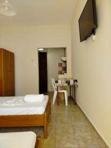 a room with two beds and a television on the wall at Eirini's Hause in Nea Moudania