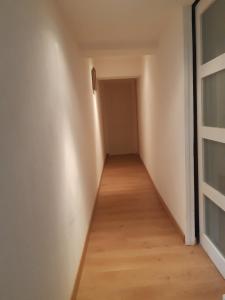 an empty hallway with a door and a wooden floor at Chic et relax familial in Montmarault
