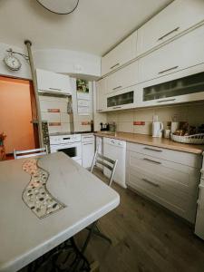 a kitchen with white cabinets and a table and chairs at Family or Group Apartment in Talsi Center in Talsi