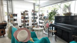 a living room with a piano and a book shelf at Lakki Village in Aegiali