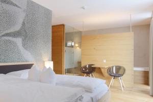 um quarto com uma cama, uma mesa e cadeiras em Steindl's Boutique Hotel em Vipiteno