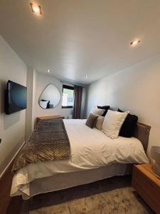 ein Schlafzimmer mit einem großen Bett und zwei Spiegeln in der Unterkunft LOUBATIERE, Superbe Appartement rénové au Coeur de la Station in Montgenèvre