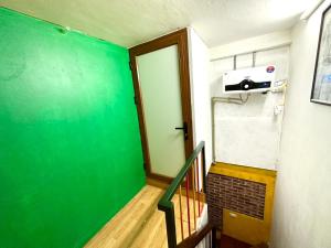 a room with a green wall and a door at Kolor Red Home,Bungalow Old Quarter,4 paxs,3 mins to Hoan Kiem Lake in Hanoi +24 photos