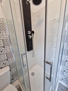 a shower with a glass door and a toilet at La famille in Angoulême
