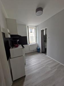 an empty kitchen with a refrigerator and a window at La famille in Angoulême