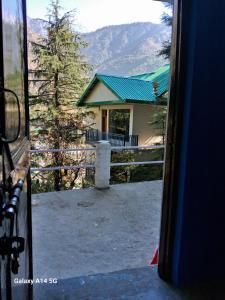 a view of a house from a bus window at Himalayan Triund Hill View Hostel in Dharamshala
