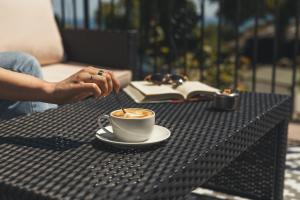 a person stirring a cup of coffee on a table at Stoke Lodge Hotel in Stoke Fleming