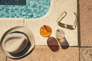 a hat and glasses next to a swimming pool at Stoke Lodge Hotel in Stoke Fleming