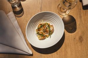 a white plate with food on a wooden table at Stoke Lodge Hotel in Stoke Fleming