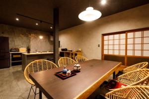 une salle à manger avec une table et des chaises en bois dans l'établissement 一棟貸切の宿 夕凪 500平方米一日一組日本庭園 3名まで同一料金 最大14名様父母ヶ浜車で10分, à Mitoyo