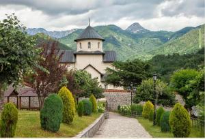 a building with a tower and a steeple in a garden at Camp Mrdak Lipovo in Kolašin