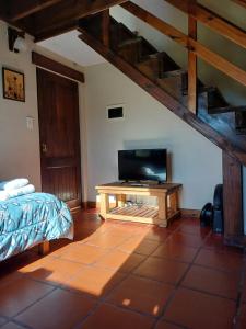 a bedroom with a bed and a tv in a room at Cabañas Las Tahonas in Azul