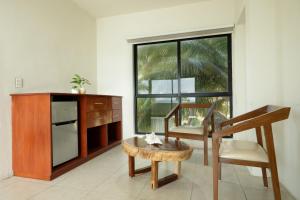 a living room with a desk and a chair and a table at Cuxos Hotel Beachfront in Isla Mujeres