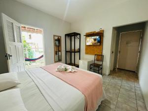 een slaapkamer met een bed met een roze deken bij Mansomar in Jericoacoara +81 foto's