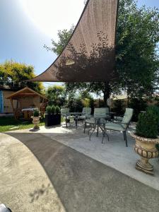 a patio with a table and chairs and a umbrella at La Mosie in Corbu