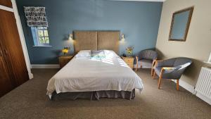a bedroom with a large bed with blue walls at Stoke Lodge Hotel in Stoke Fleming